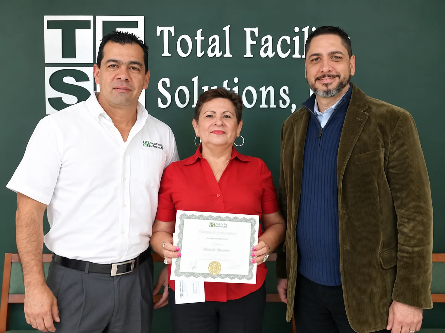 Presentación anterior de reconocimiento a empleados de TFS que muestra a los homenajeados con un certificado